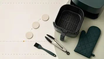 Tom airfryerkurv med tang, oljepensel, grillvott og tre blanke trinnmarkører